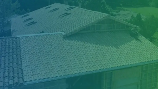 Couvreur ECOTOIT posant des tuiles sur une toiture en Gironde